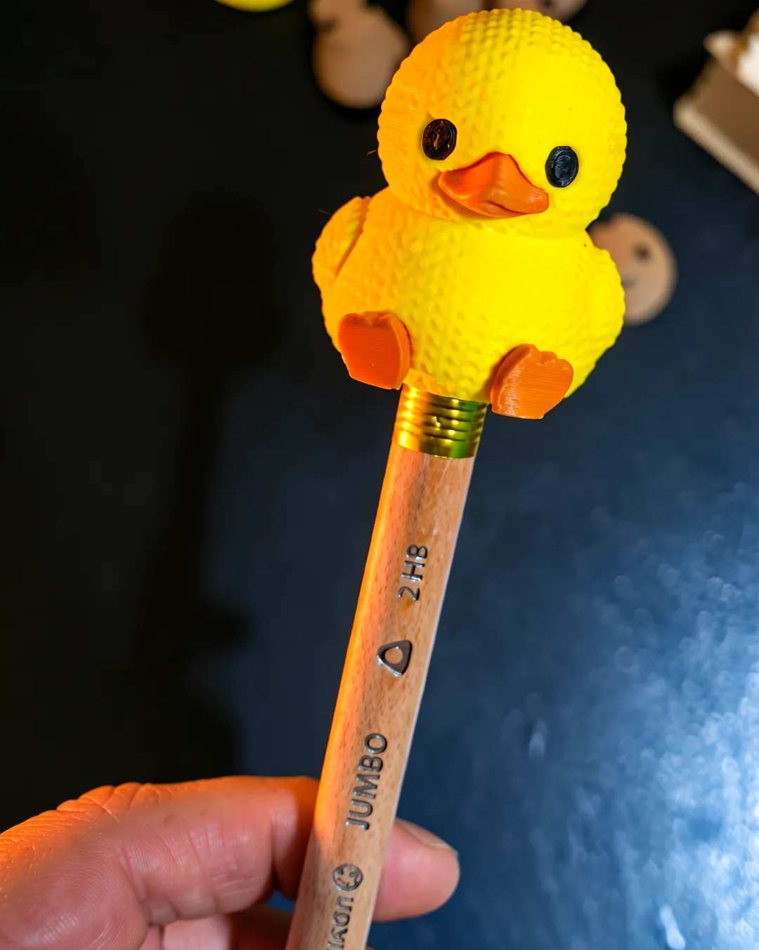 Cubrelápices en forma de pato montado sobre un lápiz