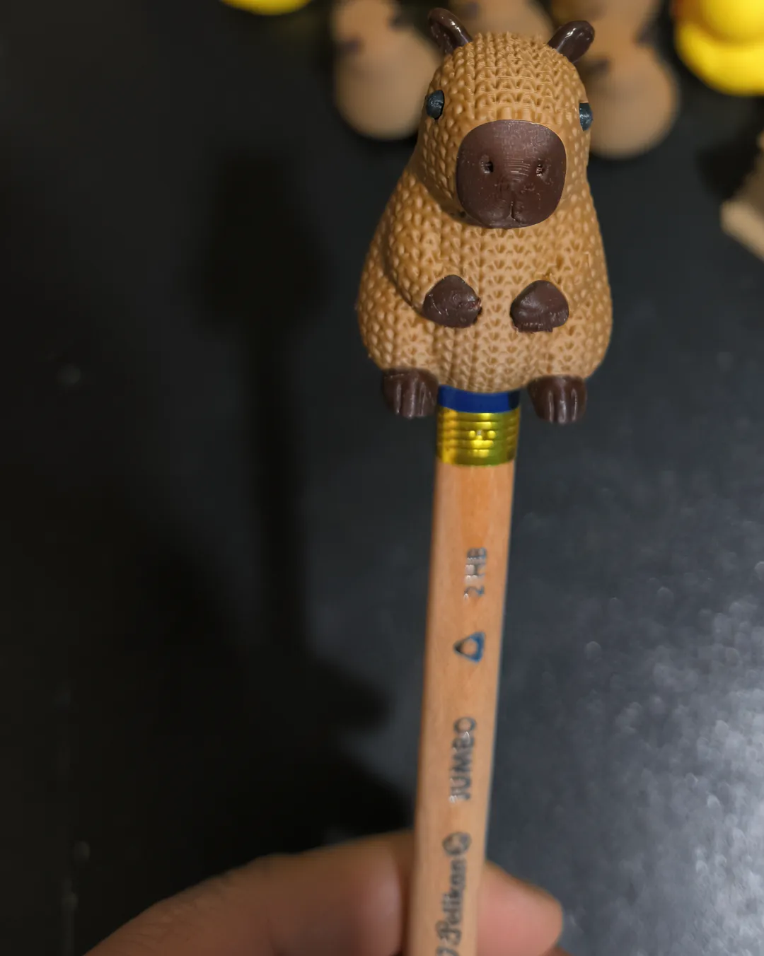 Cubrelápices en forma de capibara montado sobre un lápiz